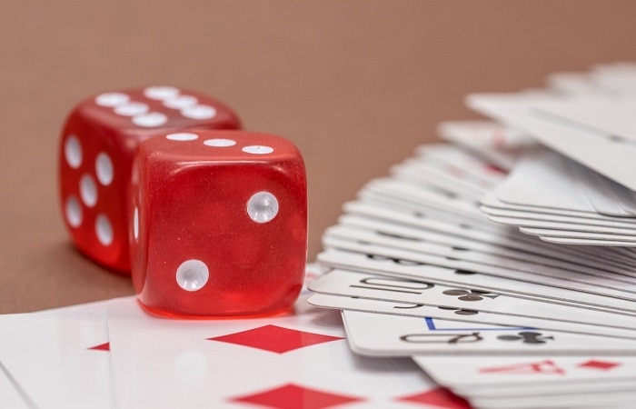 Red Dice With Cards On a Table