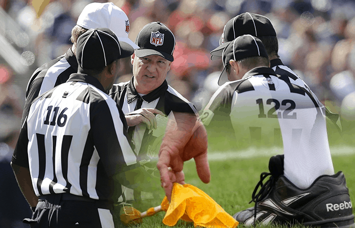 Multiple NFL Referees And A Yellow Flag
