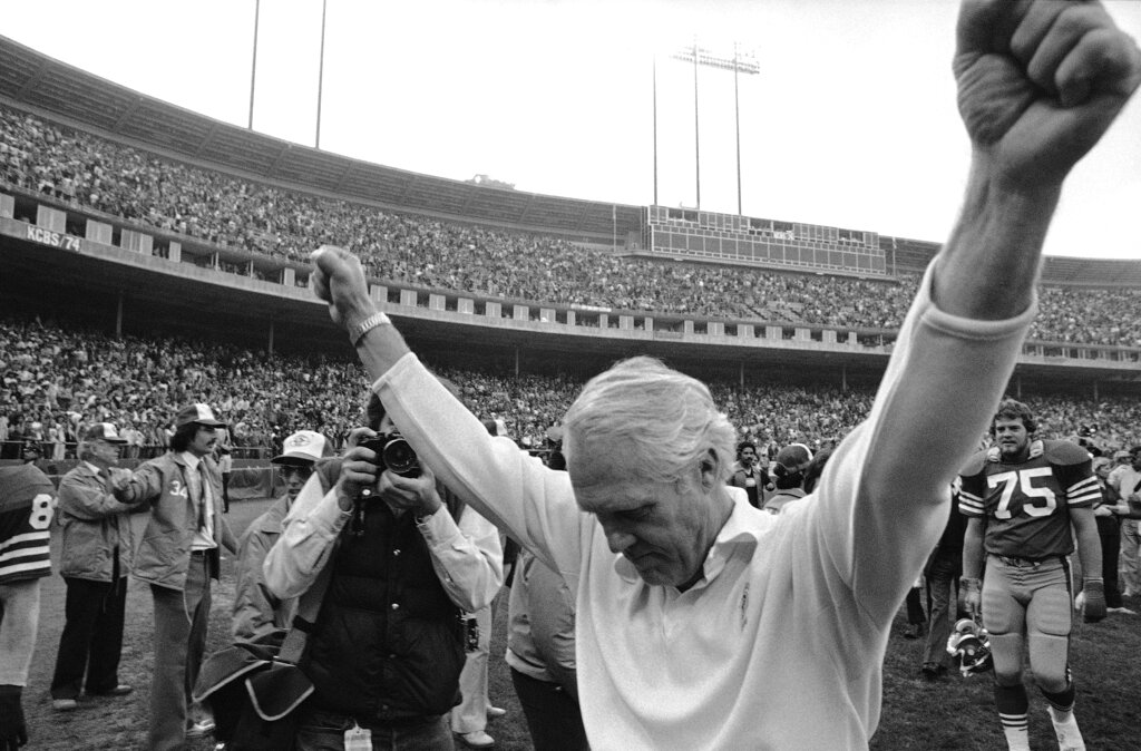 San Francisco 49ers head coach Bill Walsh holds his arms in the air in victory