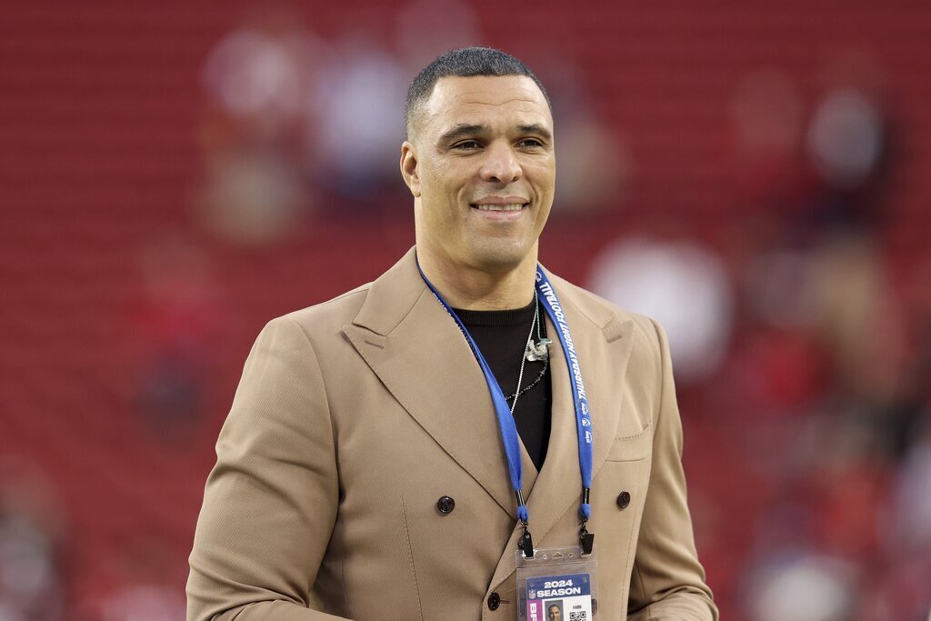 Former NFL player Tony Gonzalez walks on the field before an NFL football game