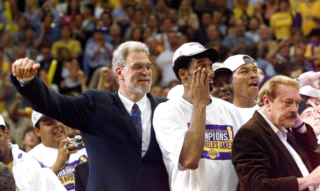 Phil Jackson holding the NBA championship trophy during a Lakers victory parade