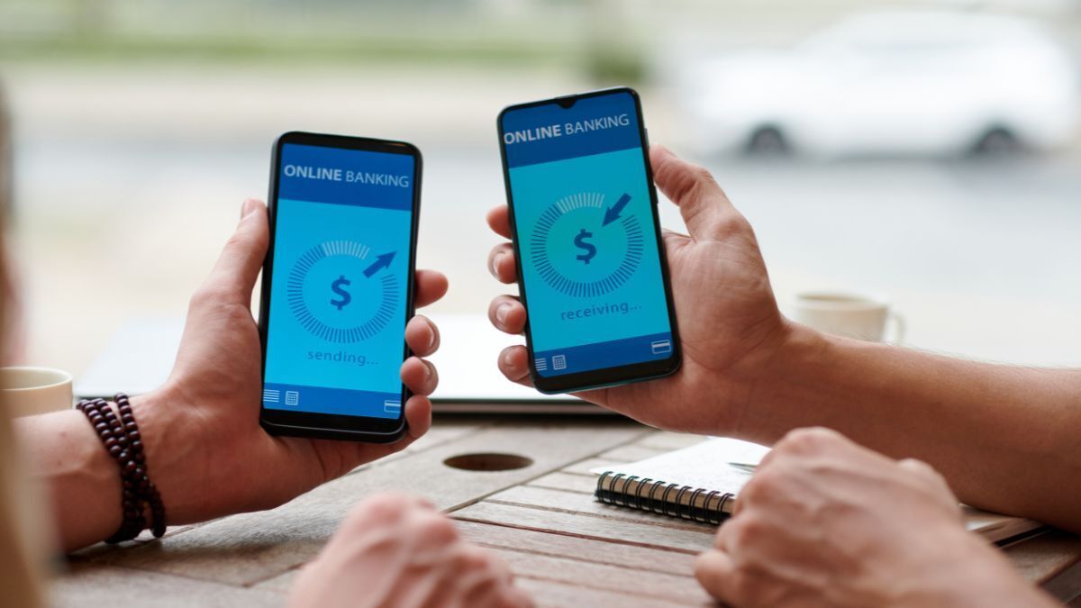 Stock image of bank transfer showing hands holding money and a bank icon