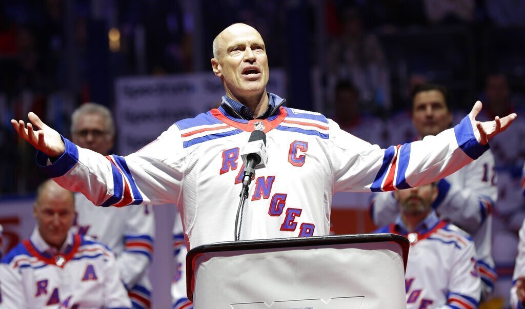 Mark Messier gestures to fans while speaking during a ceremony