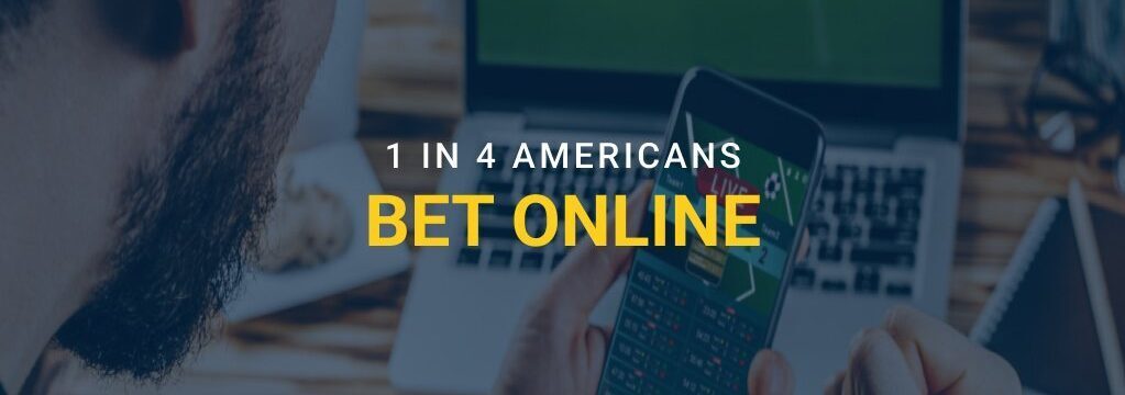 Man using a smartphone to place a sports bet, with text overlay reading “1 in 4 Americans Bet Online” and a laptop in the background