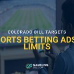 Man watching a sports game on TV while using a smartphone, with overlay text about a Colorado bill targeting sports betting ads and limits.