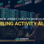 Sportsbook counter with betting odds screens in the background and text reading “New Jersey Targets Monthly Gambling Activity Alerts.”