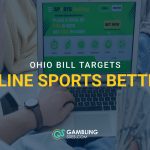 Person using a laptop with a sports betting website open, with text reading “Ohio Bill Targets Online Sports Betting” and the GamblingSites.com logo.